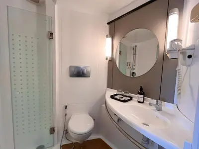 a bathroom with a toilet and a sink and a mirror at Luminor Hotel Legian Seminyak - Bali in Legian