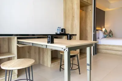 a room with a table and stools and a bed at Anagata 2 Tanjung Benoa Bali in Nusa Dua