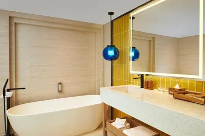 a bathroom with a tub and a sink and a mirror at voco Bali Seminyak by IHG in Seminyak