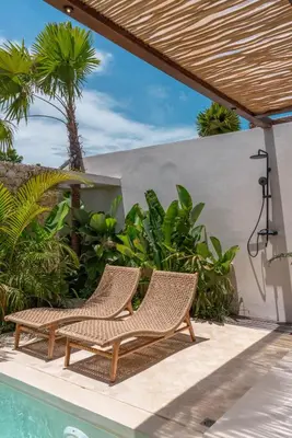 two wicker chairs sitting next to a swimming pool at Casa Melosa 1 - Romantic and Cozy 1BR Villa in the Heart of Umalas in Canggu
