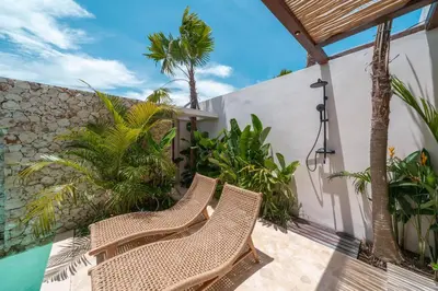 two wicker chairs on a patio with palm trees at Casa Melosa 1 - Romantic and Cozy 1BR Villa in the Heart of Umalas in Canggu