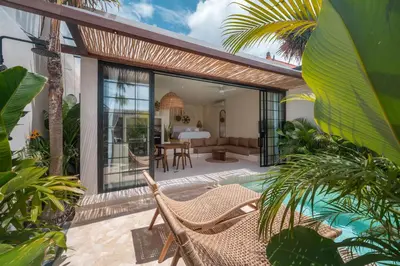 an outdoor patio with a wicker chair and a table at Casa Melosa 1 - Romantic and Cozy 1BR Villa in the Heart of Umalas in Canggu