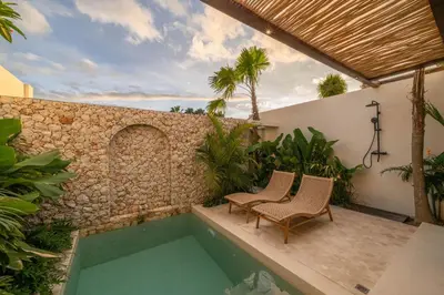 a patio with two chairs and a swimming pool at Casa Melosa 2 : Charming and Intimate 1BR Villa Nestled in Umalas in Canggu