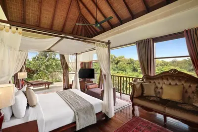 a bedroom with a canopy bed and a balcony at Barimantra 4BR Trees View Pool Villa CYN in Jimbaran