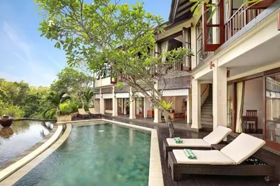 a swimming pool in front of a villa at Barimantra 4BR Trees View Pool Villa CYN in Jimbaran