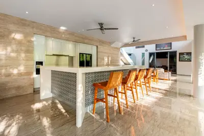 a kitchen with a bar with a bunch of chairs at Villa Eighty8 Private Residence with Gym & 20m Pool in Kerobokan