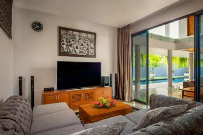 a living room with a couch and a flat screen tv at Villa Eighty8 Private Residence with Gym & 20m Pool in Kerobokan