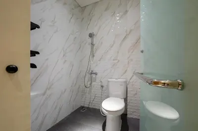 a bathroom with a shower and a toilet in it at Cove Tripuri House Bali in Denpasar