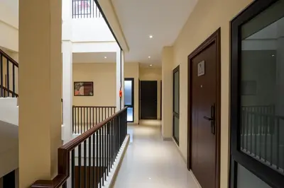 a hallway of a house with a staircase and a door at Cove Tripuri House Bali in Denpasar