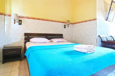 a bedroom with a bed with two towels on it at Gora Beach Inn in Kuta