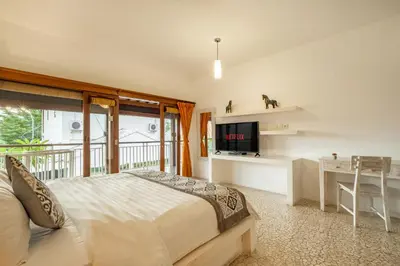 a bedroom with a bed and a desk and a television at 3 Bedroom cozy private pool Villa in Seminyak WIFI in Seminyak