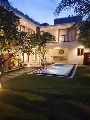 a house with a swimming pool in the yard at Villa Dharmatria in Nusa Dua