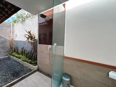a bathroom with a shower with a glass door at Astana Villas in Seminyak