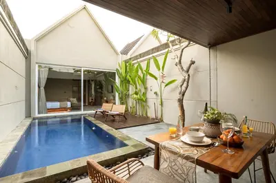 a patio with a swimming pool next to a house at Damarya Villa Canggu in Canggu