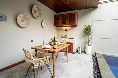 a dining room with a wooden table and chairs at Damarya Villa Canggu in Canggu