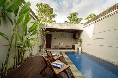a backyard with a swimming pool and a house at Damarya Villa Canggu in Canggu