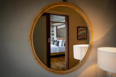 a round mirror on a wall with a bedroom at Villa Zarrin Seminyak Bali Luxury 3 bedroom villa in Seminyak