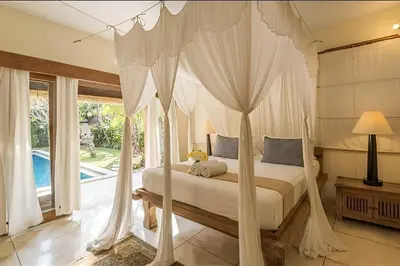 a bedroom with a canopy bed and a pool at Villa Umah Maya 3BR Seminyak in Seminyak