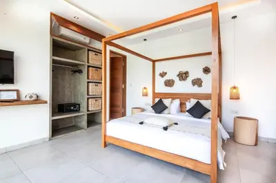 a bedroom with a bed with a wooden frame at Spectacular 4BR Villa, 400m to Beachfront Bliss in Canggu