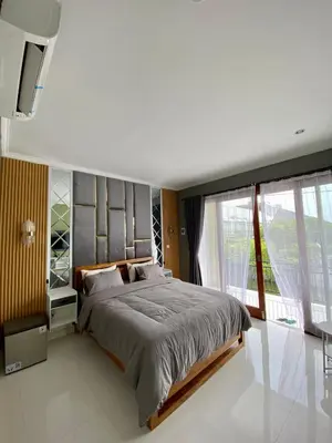 a bedroom with a large bed and a large window at Melza Room no 4 in Kerobokan