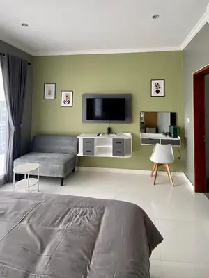 a living room with a bed and a flat screen tv at Melza Room no 4 in Kerobokan
