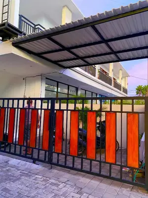 a fence with different colored doors in front of a building at Melza room no.3 in Kerobokan