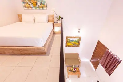 a small bedroom with a bed and a staircase at Maisaba Seminyak Loft & Villas in Seminyak