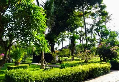 a park with lush green bushes and trees at Suite Hotel Apartment Legian by RCP in Seminyak