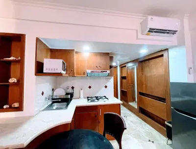 a kitchen with a sink and a stove top oven at Suite Hotel Apartment Legian by RCP in Seminyak
