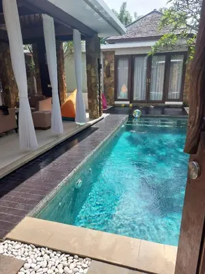 a swimming pool in front of a house at Villa Samatha in Nusa Dua
