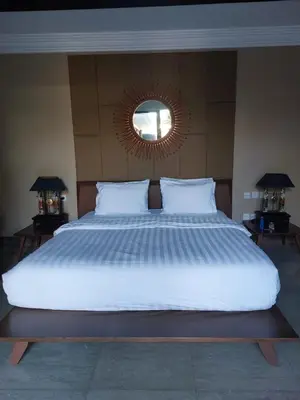 a bedroom with a large white bed with a mirror at Villa Samatha in Nusa Dua