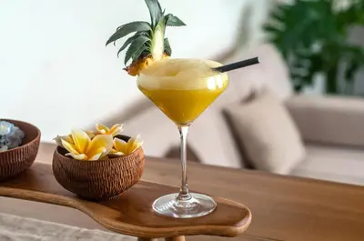 a drink in a martini glass on a wooden table at La Boutique Lux's Villas Seminyak Bali in Seminyak
