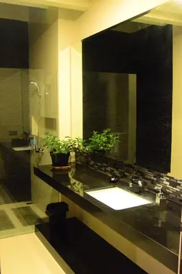 a bathroom with a sink and a large mirror at The Arnaya in Kuta