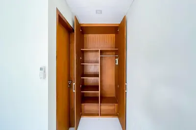 a closet with wooden doors and shelves at Aldan Guest House Syariah in Pesanggaran