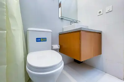 a bathroom with a white toilet and a sink at Aldan Guest House Syariah in Pesanggaran