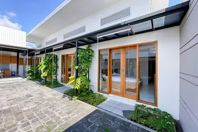 a white house with glass doors and a courtyard at Aldan Guest House Syariah in Pesanggaran