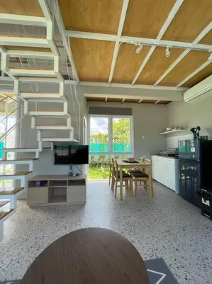 a room with a staircase and a table and a kitchen at Monty’s Villa Umalas - 1 Bedroom in Kerobokan
