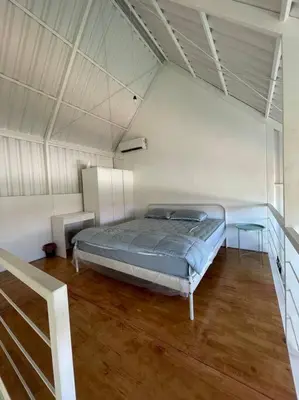 a bedroom with a bed and two tables in it at Monty’s Villa Umalas - 1 Bedroom in Kerobokan