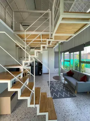 a staircase in a room with a couch and a table at Monty’s Villa Umalas - 1 Bedroom in Kerobokan