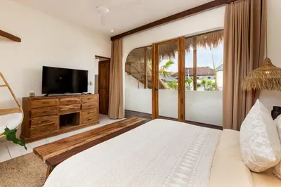 a bedroom with a large bed and a television at Villa Senya - Bali Bliss 3BR Mediterranean Escape with Private Pool, Stylish Retreat Between Seminyak & Canggu in Kerobokan