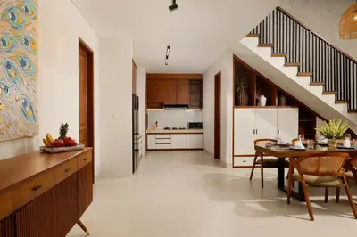a kitchen with a dining room table and a staircase at Villa Ananya Seminyak by Nakula in Seminyak