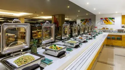 a buffet line with plates of food in a restaurant at Kuta Galleria Hotel in Kuta