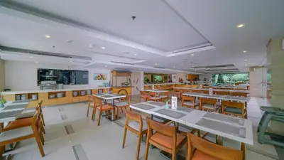 a restaurant with tables and chairs and a bar at Kuta Galleria Hotel in Kuta