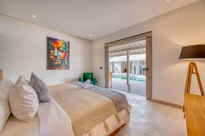 a bedroom with a large bed and a sliding glass door at Beautiful villa Yang Tao in the heart of Seminyak with private staff in Seminyak