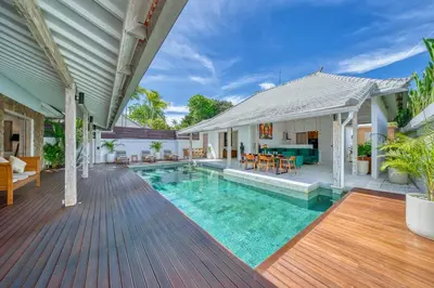 a house with a swimming pool and a wooden deck at Beautiful villa Yang Tao in the heart of Seminyak with private staff in Seminyak