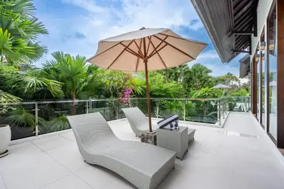 a patio with two chairs and an umbrella at Villa Amelie by JB Villas in Seminyak