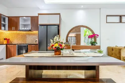 a kitchen with a kitchen island with flowers on it at Villa Amelie by JB Villas in Seminyak