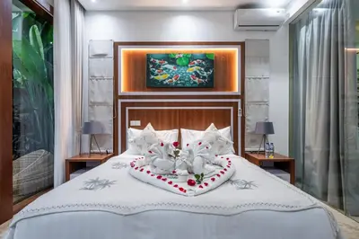 a bedroom with a bed with two white cats on it at Villa Amelie by JB Villas in Seminyak
