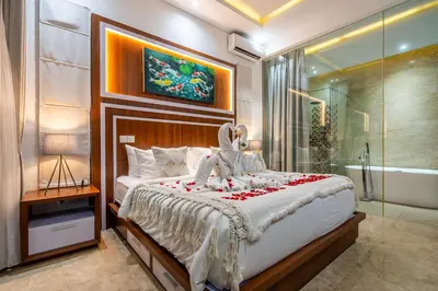 a bedroom with a bed and a glass shower at Villa Amelie by JB Villas in Seminyak
