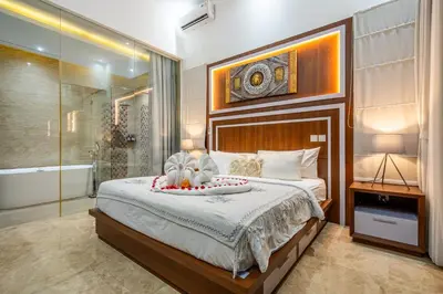 a bedroom with a large bed and a shower at Villa Amelie by JB Villas in Seminyak